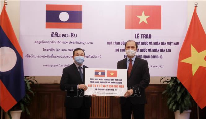 Thứ trưởng Ngoại giao Nguyễn Quốc Dũng trao tượng trưng khoản hỗ trợ của Việt Nam giúp Lào ứng phó dịch Covid-19 cho Đại sứ Lào tại Việt Nam Sengphet Houngboungnuang. Ảnh: TTXVN