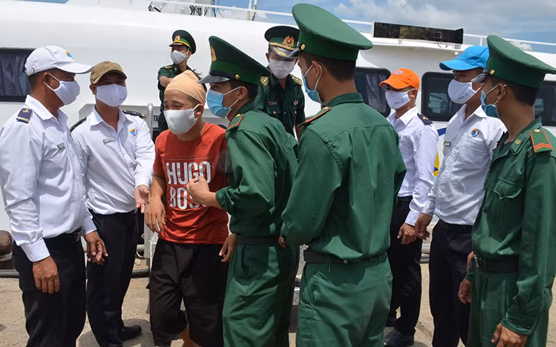 Cán bộ, chiến sĩ Bộ đội Biên phòng tỉnh Bình Thuận đón các ngư dân bị nạn được đưa từ Phú Quý vào đất liền ngay sau khi tàu cập cảng Phan Thiết.