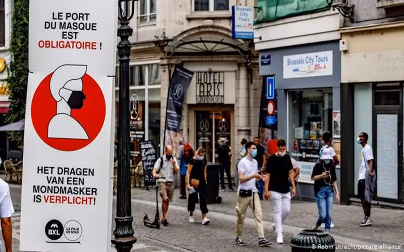 Người dân đeo khẩu trang khi di chuyển trên đường phố Brussels, Bỉ. (Ảnh: DW)