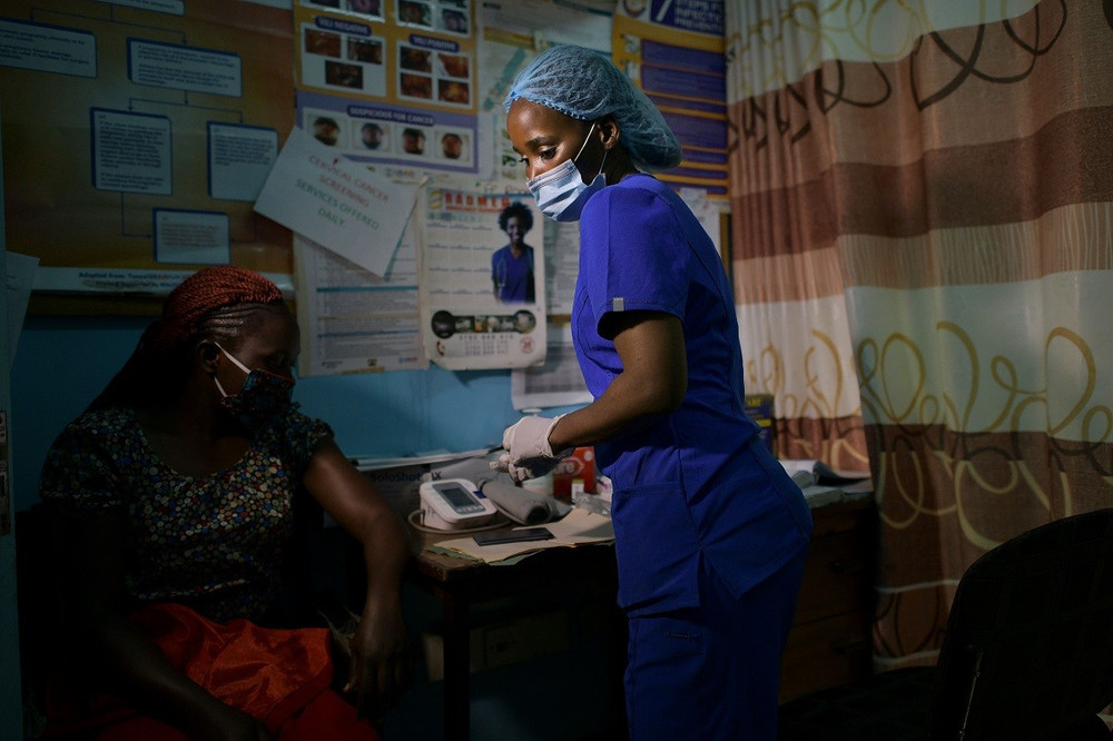 Một y tá tình nguyện kiểm tra sức khỏe cho một người dân tạit trung tâm y tế ở Nairobi, Kenya, nơi tuyên truyền cho công chúng về cách phòng chống nhiễm Covid-19. Ảnh: Getty Images. Nếu các nước giàu không chia sẻ vaccine, đại dịch có thể kéo dài thêm 7 năm -0