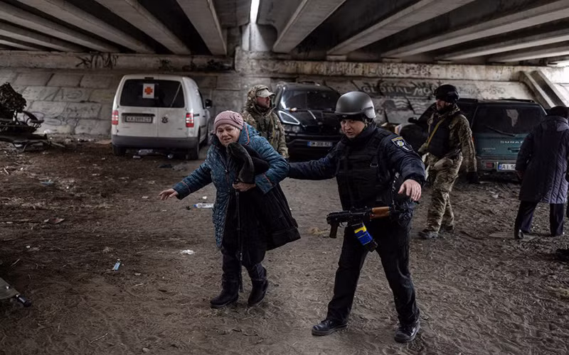 Quân nhân Ukraine hỗ trợ cụ bà tại khu vực Irpin, gần thủ đô Kiev, di dời đến nơi an toàn, ngày 13/3. (Ảnh: Reuters)