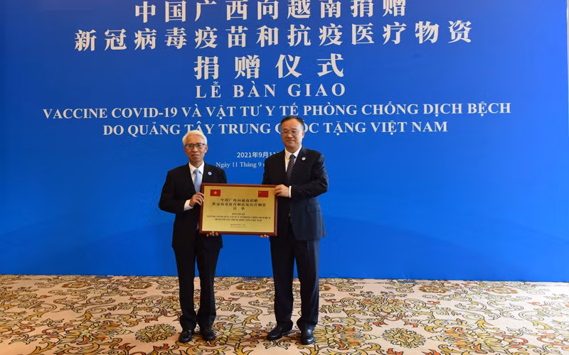 Đại sứ Việt Nam tại Trung Quốc Phạm Sao Mai (trái) thay mặt tiếp nhận số hàng viện trợ từ Phó Chủ tịch Chính quyền Khu tự trị Dân tộc Choang Quảng Tây Hoàng Tuấn Hoa. (Ảnh: Mạnh Cường - TTXVN)