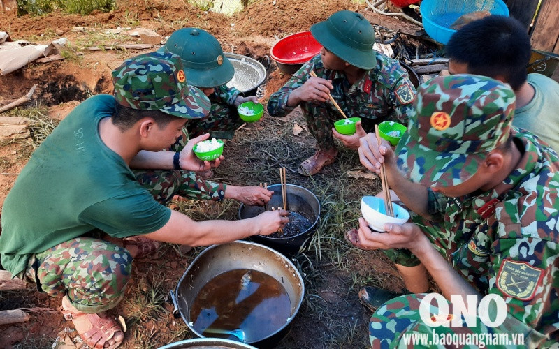 Bữa cơm vội vàng của lực lượng tìm kiếm. (Ảnh: Báo Quảng Nam) baoQN4-1604050401167.jpg