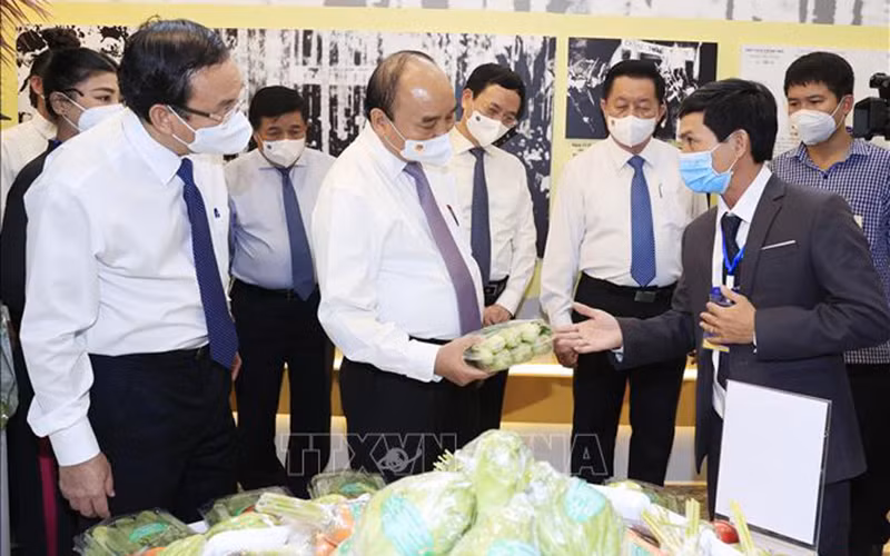 Chủ tịch nước Nguyễn Xuân Phúc thăm khu trưng bày các sản phẩm tiêu biểu của huyện Hóc Môn và Củ Chi. (Ảnh: TTXVN)