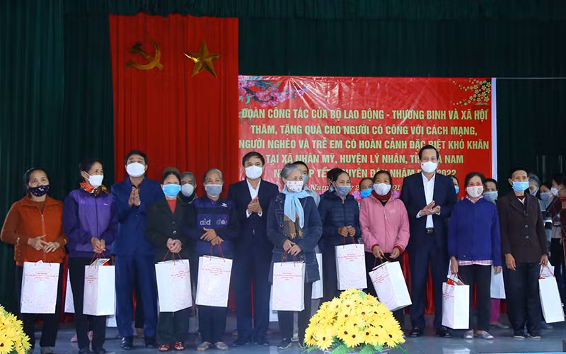Bộ trưởng Đào Ngọc Dung, lãnh đạo tỉnh Hà Nam tặng quà gia đình chính sách, hộ nghèo tại chương trình. (Ảnh: Molisa)