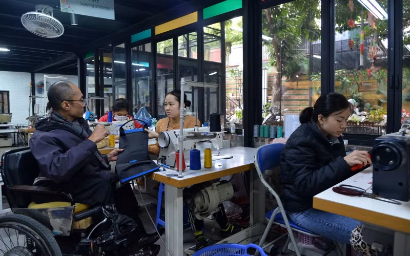 Anh Pham Việt Hoài trao đổi với nhân viên xưởng may về sản phẩm đang hoàn thiện.