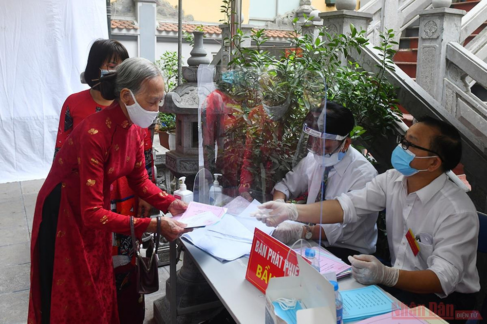 Cử tri nhận phiếu bầu tại khu vực bỏ phiếu số 7, phường Đồng Tâm, quận Hai Bà Trưng. Ảnh: Thủy Nguyên Người dân Thủ đô trong “Ngày hội non sông” -1