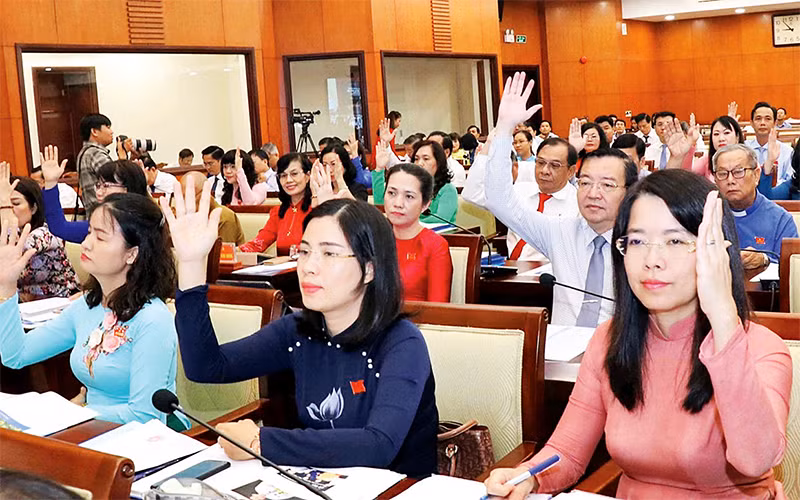 Các đại biểu HÐND thành phố Hồ Chí Minh khóa 9 biểu quyết thông qua Nghị quyết tại một kỳ họp.