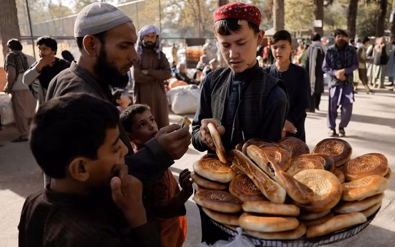 Người dân Afghanistan mua bánh mì tại một điểm tạm trú ở công viên Shahr-e Naw, Kabul, Afghanistan, ngày 4/10/2021. (Ảnh: Reuters)