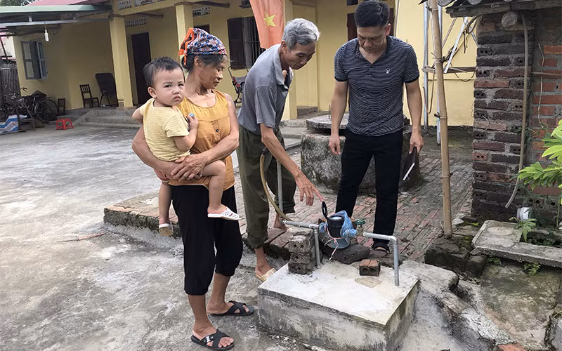 Tổ vận hành công trình nước sinh hoạt xã Hoàng Tung, huyện Hòa An (Cao Bằng) đi chốt số nước tại nhà dân.