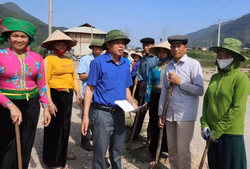 Ông Lò Văn Pháng (đứng giữa áo xanh) vận động người dân làm đường giao thông nông thôn.