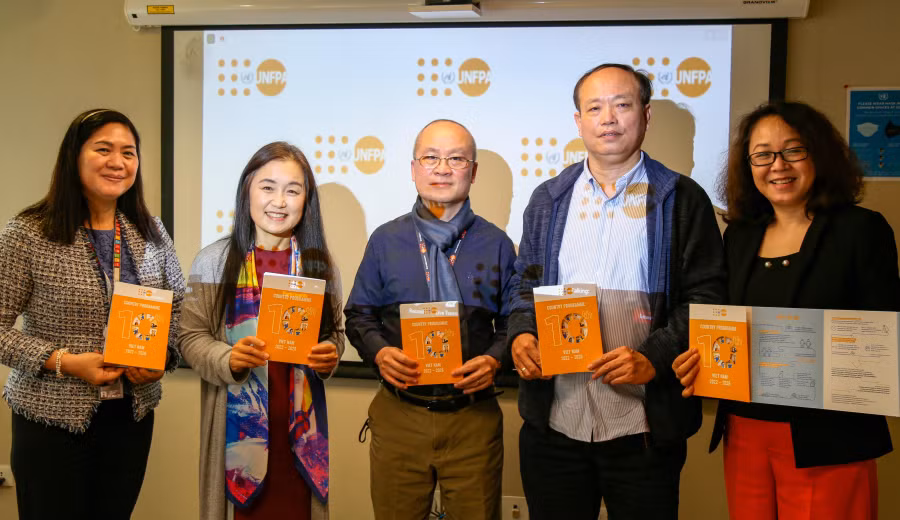 Các đại biểu cầm trên tay tờ thông tin Chương trình Quốc gia lần thứ 10 dành cho Việt Nam, giai đoạn 2022-2026. (Ảnh: UNFPA)