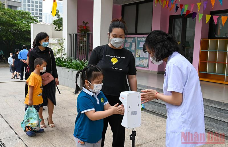 Tại Trường mầm non Hoa Hướng Dương (Cầu Giấy), ngay từ sáng sớm, các cô giáo đã ra tận cổng trường đón các trẻ, hướng dẫn rửa tay sát khuẩn, kiểm tra thân nhiệt trước khi vào lớp. Niềm vui trẻ thơ trong ngày trở lại trường -0