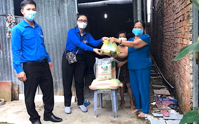 Đội hình áo xanh tình nguyện miệt rừng U Minh hạ hỗ trợ mang thực phẩm xuống nhà dân.