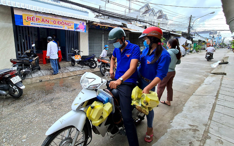 Đội hình áo xanh tình nguyện thành phố Cà Mau mang các phần cơm “0 đồng” trao cho hộ khó khăn trong mùa dịch. Shipper “0 đồng” miệt sông nước Cà Mau -0