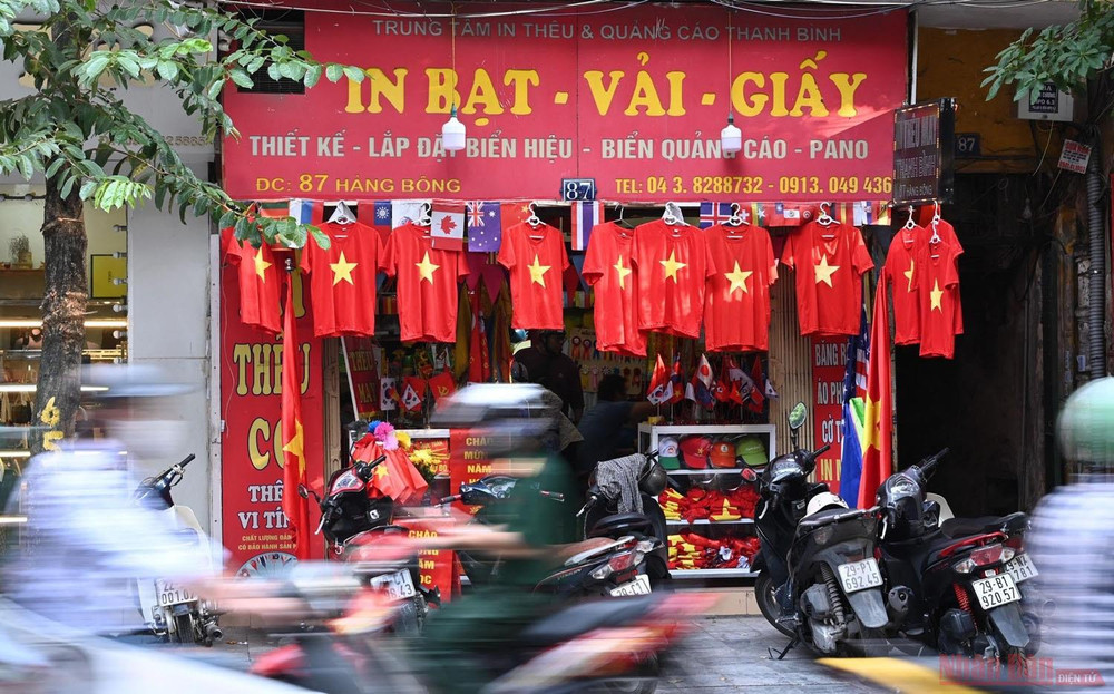 Một cửa hàng bán cờ Tổ quốc, áo in hình cờ đỏ sao vàng trên phố Hàng Bông nhộn nhịp khách ra vào. Đường phố Hà Nội rực rỡ màu cờ Tổ quốc chào mừng 75 năm Quốc khánh -0