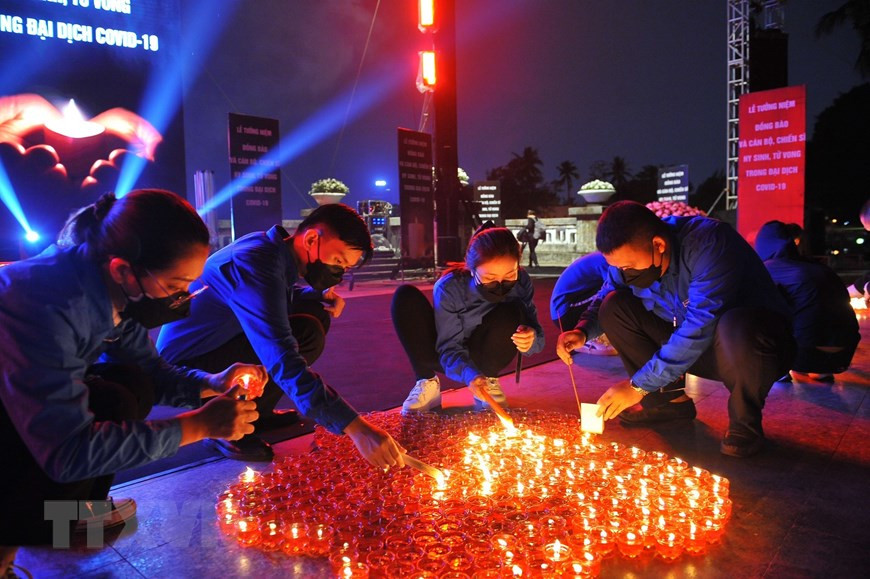 Tại Công viên Thống Nhất (Hà Nội), các đại biểu và nhân dân thắp nến tưởng niệm đồng bào và cán bộ, chiến sĩ hy sinh, tử vong trong đại dịch Covid-19. (Ảnh: TTXVN) Lễ tưởng niệm đồng bào tử vong và cán bộ, chiến sĩ hy sinh trong dịch Covid-19 -0