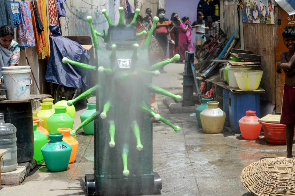Người dân tại Chennai, Ấn Độ đang theo dõi robot có hình dáng giống virus corona xịt khử trùng. (Ảnh: Getty Images) 2.jpg -0