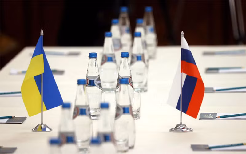 Quốc kỳ Nga và Ukraine trên bàn đàm phán trước khi hai phái đoàn bắt đầu đàm phán tại vùng Gomel, gần biên giới Belarus-Ukraine, ngày 28/2. (Ảnh: Reuters)