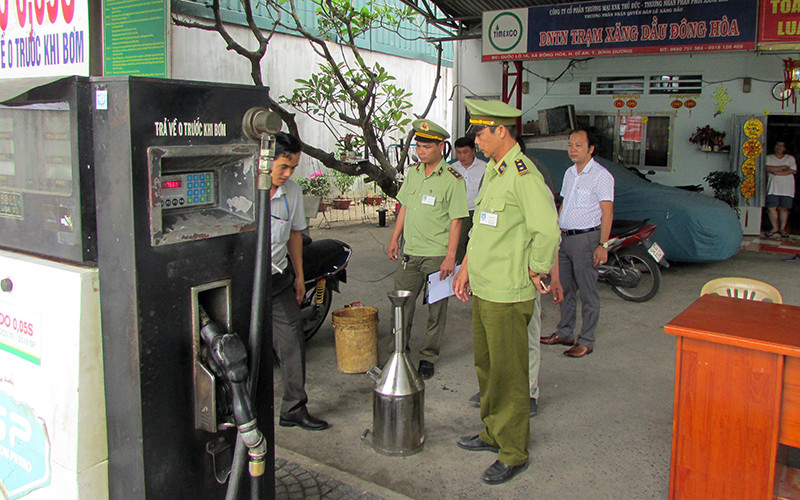 Lực lượng quản lý thị trường lấy mẫu, kiểm tra hoạt động kinh doanh xăng dầu tại tỉnh Bình Dương.