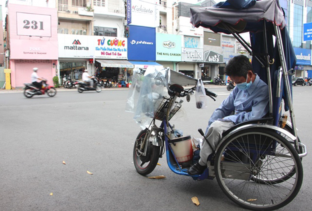 Một người bán vé số dừng xe bán vé số trên xe lăn trong thời gian giãn cách xã hội. Người dân TP Hồ Chí Minh trong thời gian giãn cách do dịch Covid-19 -0