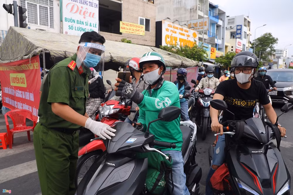 Người dân đi qua chốt Phan Văn Trị - Phạm Văn Đồng khai báo y tế nhanh.