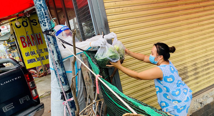 Lực lượng tình nguyện SOS của Trung tâm An sinh trao quà hỗ trợ cho một người dân có hoàn cảnh khó khăn tại quận Bình Tân. (Ảnh: Quang Quý) Để đạt mục tiêu kép vững chắc -0