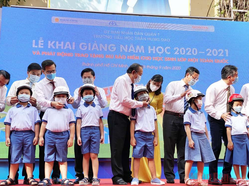Phó Thủ tướng Trương Hòa Bình cùng các đại biểu trao tặng mũ bảo hiểm cho các em học sinh lớp Một tại trường Tiểu học Trần Hưng Đạo, quận 1, TP Hồ Chí Minh. (Ảnh: QUÝ HIỀN) Phó Thủ tướng Trương Hoà Bình dự lễ khai giảng và trao mũ Bảo hiểm cho học sinh tiểu học -0