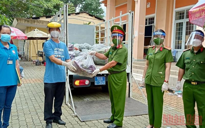 Đại diện Văn phòng Cơ quan Cảnh sát Điều tra Bộ Công an trao quà cho lãnh đạo UBND phường 27, quận Bình Thạnh (TP Hồ Chí Minh) sáng 15/8.