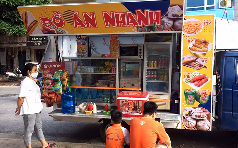 Bán thức ăn nhanh cho học sinh tại cổng trường học tiềm ẩn nhiều rủi ro về an toàn vệ sinh thực phẩm. Trong ảnh: Xe bán đồ ăn nhanh cho học sinh trên phố Hòa Mã, quận Hai Bà Trưng (Hà Nội). Ảnh: NGUYỄN ÐĂNG