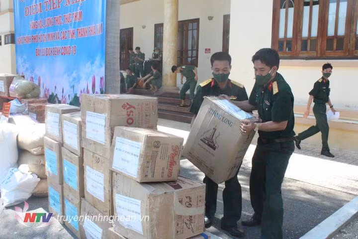 Cán bộ, nhân viên Cục Hậu cần Quân khu 4 bốc xếp hàng hóa ủng hộ TP Hồ Chí Minh chống dịch. (Ảnh: Truyền hình Nghệ An).