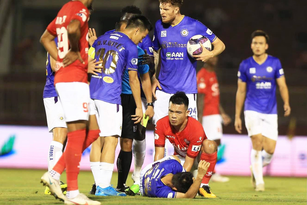 Hữu Thịnh cố gắng cố định chân giúp Hùng Dũng sau tình huống cướp bóng nguy hiểm. (Ảnh: HanoiFC)