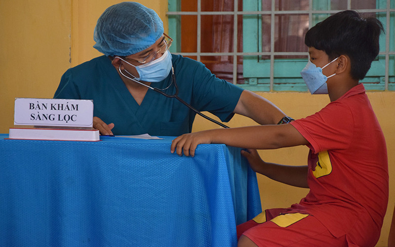 Trước khi được tiêm vaccine phòng Covid-19, các em được nhân viên y tế tư vấn, khám sàng lọc. Tiêm vaccine phòng Covid-19 đầu tiên cho trẻ từ 5 đến dưới 12 tuổi ở Đồng Tháp -0