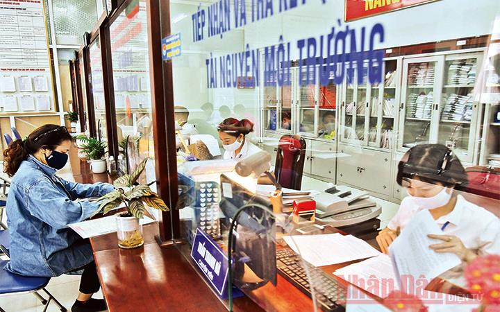 Cán bộ Bộ phận một cửa UBND quận Bắc Từ Liêm giải quyết thủ tục hành chính cho người dân. Ảnh minh họa: ANH VŨ