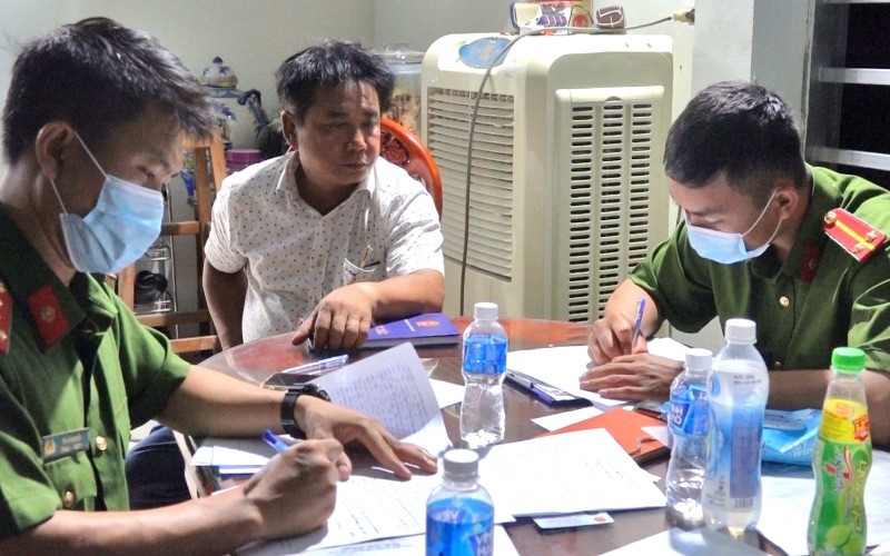 Cơ quan Công an tiến hành lấy lời khai Nguyễn Huy Đạt (áo trắng), đối tượng cầm đầu trong đường dây sản xuất xăng, dầu giả. Phát hiện đường dây sản xuất xăng, dầu giả quy mô lớn ở tỉnh Bình Thuận -0