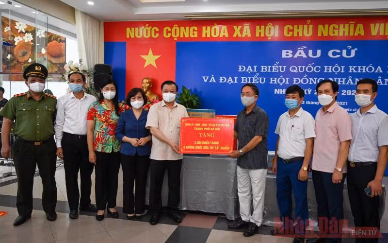 Bí thư Thành uỷ Đinh Tiến Dũng tặng quà hỗ trợ công tác phòng, chống dịch Covid-19 cho Tổ bầu cử số 8, phường Phú Thượng, quận Tây Hồ. (Ảnh: Duy Linh)