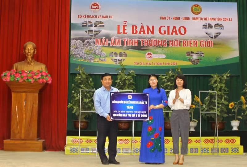 Đồng chí Nguyễn Chí Dũng trao tặng biển hỗ trợ 100 căn nhà cho huyện Sốp Cộp. 