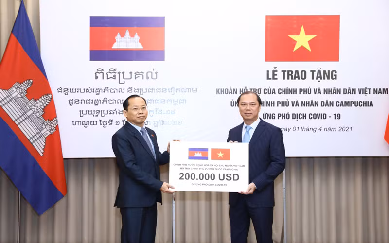 Thứ trưởng Ngoại giao Nguyễn Quốc Dũng trao tượng trưng cho Đại sứ Campuchia tại Việt Nam Chay Navuth khoản hỗ trợ 200.000 USD. (Ảnh: Bộ Ngoại giao Việt Nam)