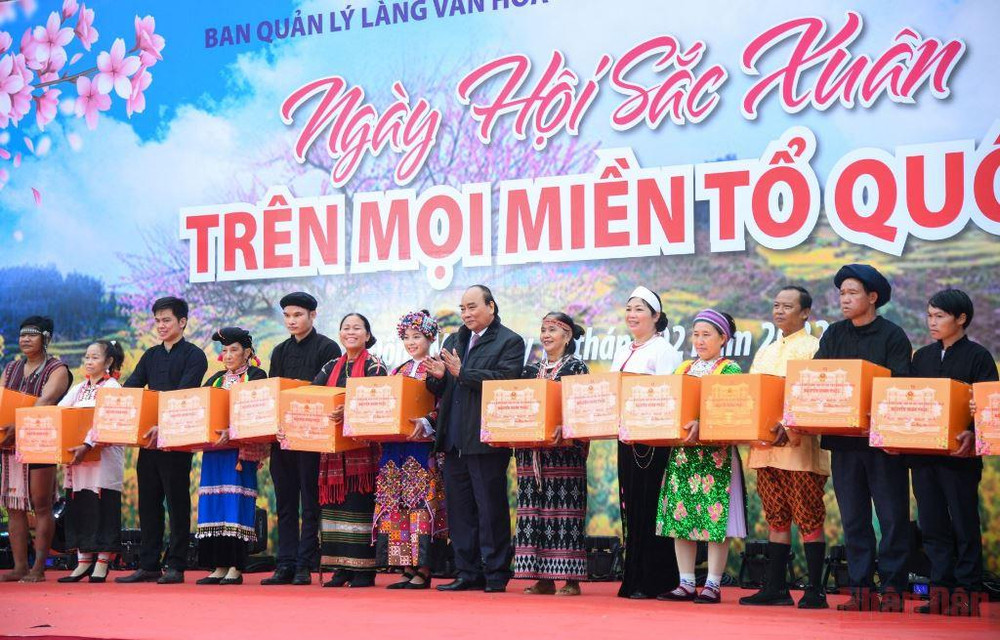 Chủ tịch nước Nguyễn Xuân Phúc trao quà cho đồng bào dân tộc tại Làng Văn hóa-Du lịch các dân tộc Việt Nam. (Ảnh: THÀNH ĐẠT) Lan tỏa những vẻ đẹp đặc sắc của văn hóa các dân tộc trong cuộc sống -0