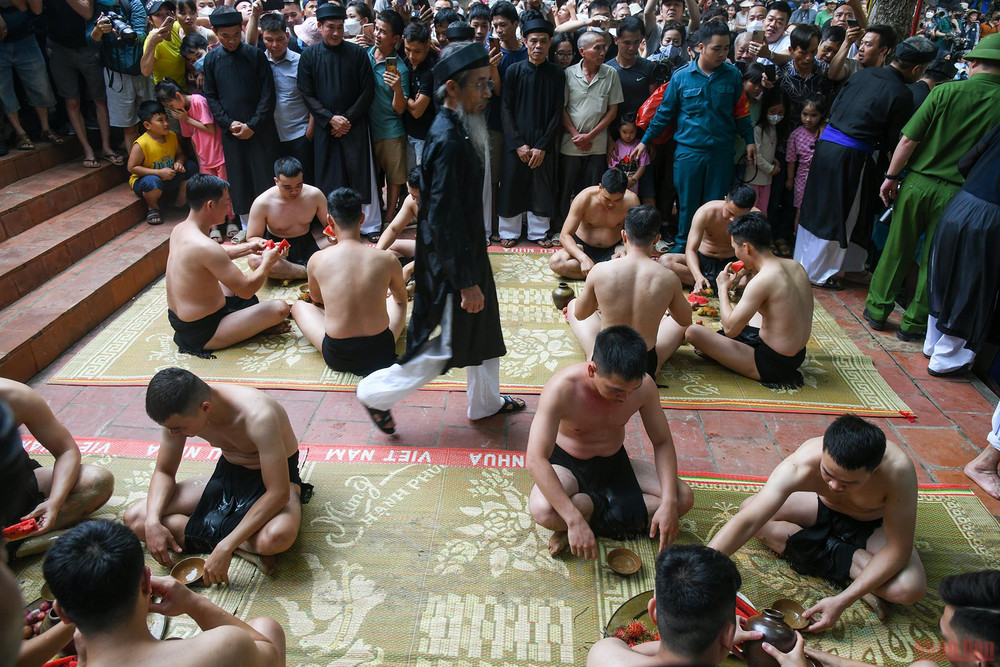 16 thanh niên khỏe mạnh tham gia gọi là quân cầu, chia làm 2 giáp trên và dưới, mỗi giáp 8 người. Tất cả đóng khố, cởi trần. Trước khi ra vật cầu họ làm lễ ở sân đền, uống rượu và ăn hoa quả để tăng dũng khí. Bắc Giang: Độc đáo thanh niên đóng khố “vật cầu bùn” -0