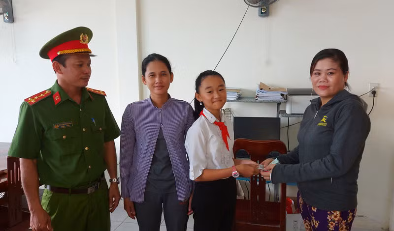 Em Nguyễn Thị Như Ý trao trả số tiền gần 14 triệu đồng cho người đánh rơi. (Ảnh: VŨ CHIẾN).