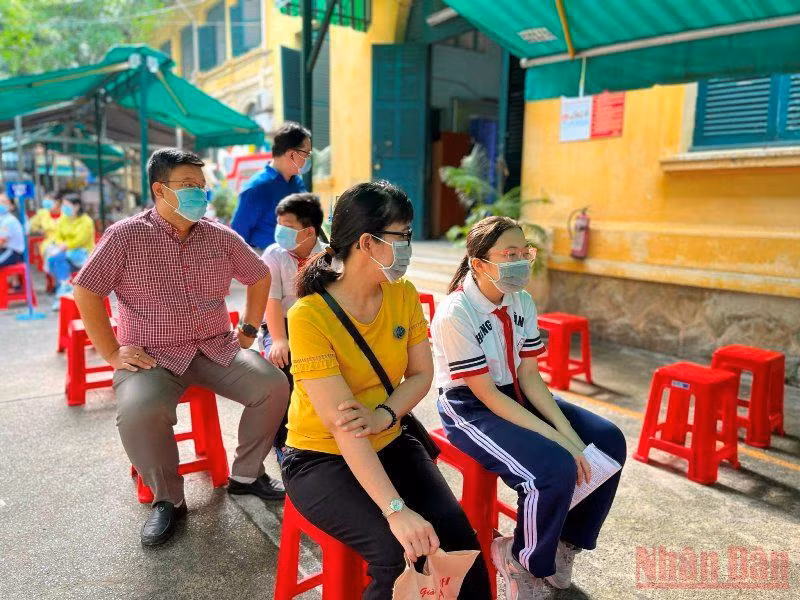 Phụ huynh và trẻ chờ đến lượt tiêm tại điểm trường THCS Hồng Bàng.