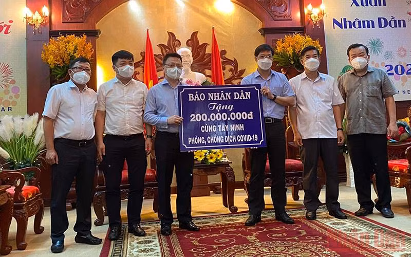 Đồng chí Lê Quốc Minh (trái) trao biển tượng trưng kinh phí chống dịch cho đồng chí Nguyễn Thành Tâm.