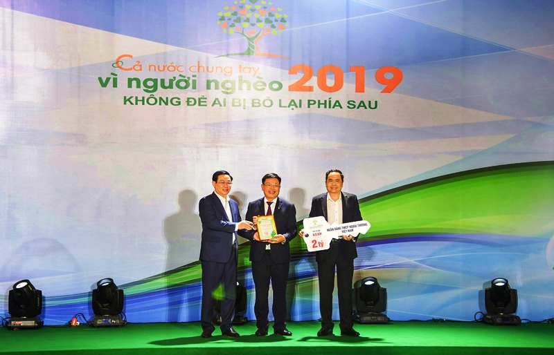 Đồng chí Đào Minh Tuấn - Phó Tổng Giám đốc, Chủ tịch Công đoàn Vietcombank (đứng giữa) trao biển tượng trưng số tiền ủng hộ người nghèo của Vietcombank và chụp ảnh lưu niệm cùng đồng chí Vương Đình Huệ (bên trái) - Ủy viên Bộ Chính trị, Phó Thủ tướng Chính phủ (nay là Bí thư Thành ủy Hà Nội) và đồng chí Trần Thanh Mẫn (bên phải) - Bí thư T.Ư Đảng, Chủ tịch Ủy ban T.Ư MTTQ Việt Nam. Vietcombank - Ngân hàng tâm huyết với công tác an sinh xã hội và hỗ trợ cộng đồng -0