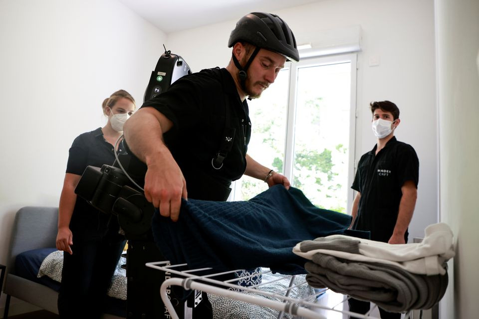 Anh Kevin Piette đang sử dụng khung xương để học cách đi lại và làm việc. (Ảnh: Reuters) Người cha chế tạo khung xương giúp con trai ngồi xe lăn đi lại -0