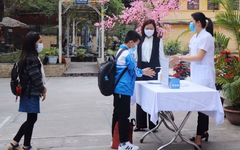 Giáo viên Trường tiểu học Ngô Sĩ Liên (TP Bắc Giang) hướng dẫn học sinh sát khuẩn tay trước khi vào lớp. (Ảnh: Lệ Thanh)