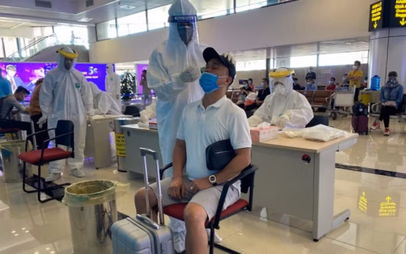 Lấy mẫu xét nghiệm nhanh Covid-19 cho hành khách tại sân bay Nội Bài.