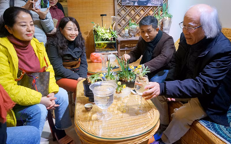 Nghệ nhân Nguyễn Phú Cường (ngoài cùng bên phải) hướng dẫn cách chăm sóc hoa thủy tiên.