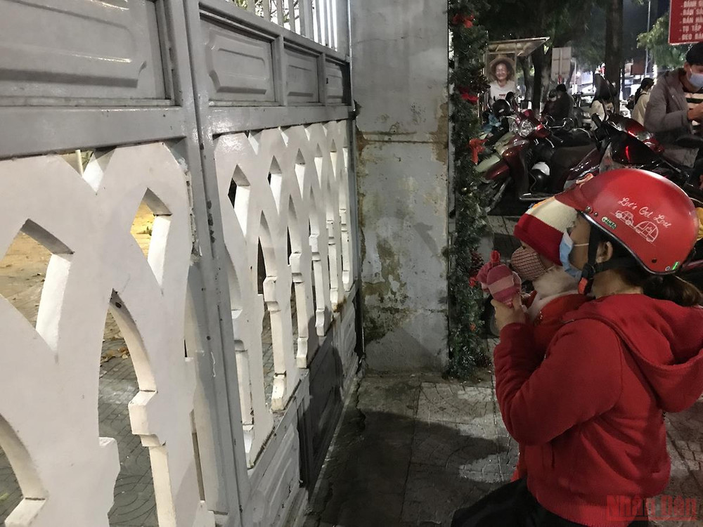 Một em nhỏ được mẹ đưa đến trước Nhà thờ Chính toà cầu nguyện. A_4_Da_nang-1640355084755.jpeg