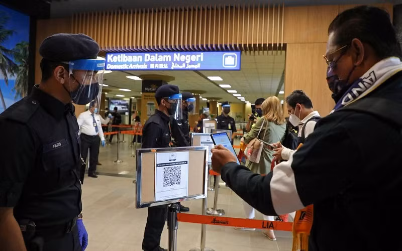 Khách du lịch quét mã QR để làm thủ tục tại sân bay khi Langkawi mở cửa trở lại cho du lịch nội địa, ngày 16/9/2021. (Ảnh: Reuters)